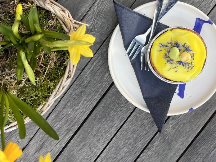 Påskeliljer og anretning  med påskekage på et bord
